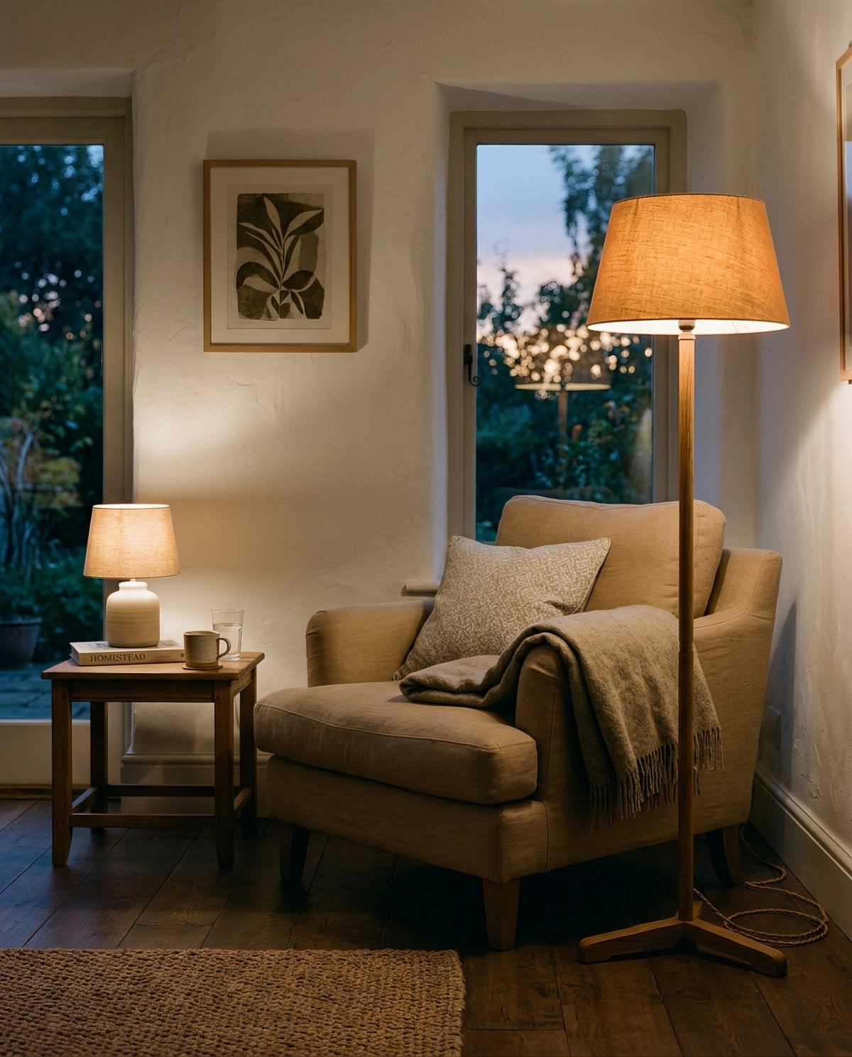 Armchair lit by a floor lamp and a small table lamp in a dim room