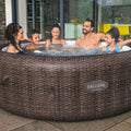 Family | Five people gathered around the spa in an indoor-outdoor evening setting