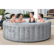In use | Four adults sitting in the filled gray hot tub on a tiled patio