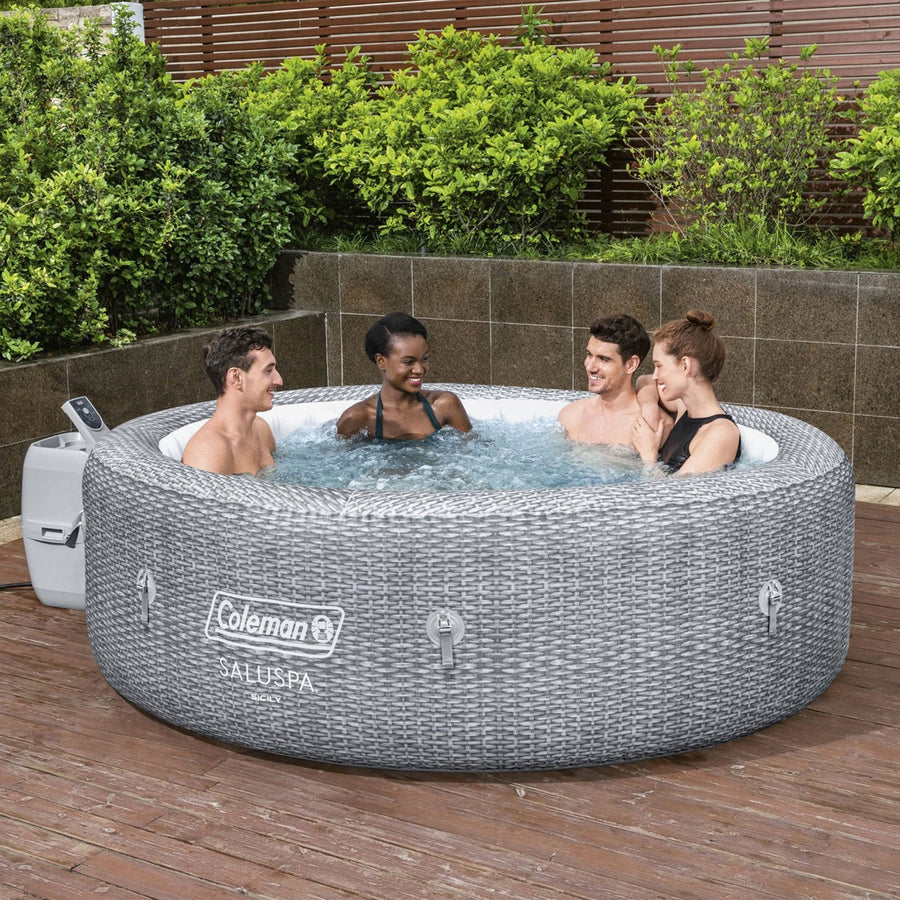 In use | Four adults relaxing together in the filled round hot tub on a stone patio