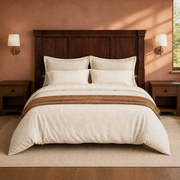 Clay view | Nearly front-facing clay-toned bedroom view of the headboard, bedding, nightstands and sconces