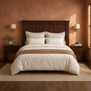 Clay room | Centered headboard in a clay-toned bedroom with brass sconces, rug and warm light
