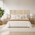 Airy room | Headboard centered in a bright bedroom with pale wood nightstands, matching lamps, curtains, and a plant