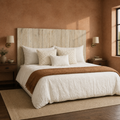 Clay corner | Angled clay-room view of the headboard with walnut nightstands, brass sconces, and a rug