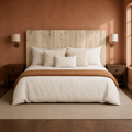 Clay room | Headboard centered in a clay-toned bedroom with brass sconces, walnut tables, and a patterned rug