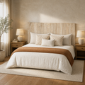 Angle | Three-quarter bedroom view showing the wood panel headboard behind pillows, bed linens, and a side table