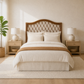 Airy room | Brown rattan headboard centered in a bright bedroom with light wood nightstands