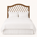 Front | Straight-on studio view of the arched rattan headboard with open diamond lattice