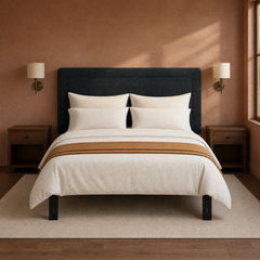 Room 3 | Dark upholstered panel headboard against a clay wall with matching sconces and nightstands