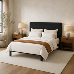Room 1 angle | Three-quarter view showing the rectangular padded headboard, rounded corners, and frame-mounted legs