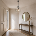 Entryway | the same pendant hanging in a bright entryway beside a console and mirror