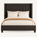 Detail | Close studio view of the dark gray fabric, button tufting, and nailhead trim on the wingback headboard