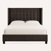 Front | Straight-on studio view of the dark gray upholstered bed, showing the button tufting and nailhead-trimmed wings