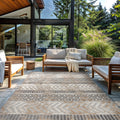 Peris geometric rug on an outdoor patio with wood-frame lounge seating