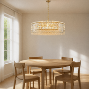 Dining room | gold-tone crystal drum chandelier above a round oak table with a left window