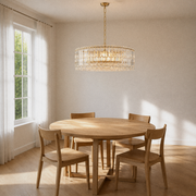 Dining room angle | gold-tone crystal drum chandelier over a round oak table from a higher corner view