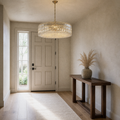 Entryway | gold-tone crystal drum chandelier above a console beside a tall sidelight