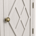 Hardware | round antique-brass ringed knob set against the X-diamond door overlay