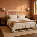 Clay corner | White bed viewed from the corner in a terracotta room with wood nightstands