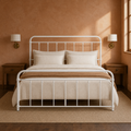 Clay room | White spindle bed against a warm terracotta wall with brass sconces