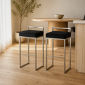 In a room | both matching stools at a pale-oak dining room's kitchen island edge, soft morning sidelight from the left