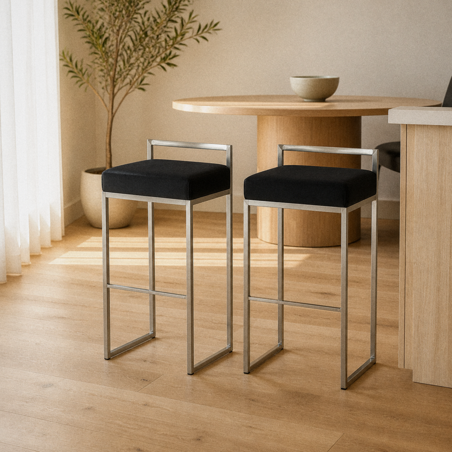 In a room | both matching stools at a pale-oak dining room's kitchen island edge, soft morning sidelight from the left