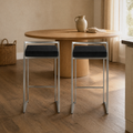 In a room | both matching stools at a plaster dining room's kitchen island edge, low golden afternoon light from the right
