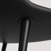 Closer | where a slim black metal leg meets the underside of the seat shell
