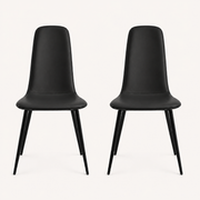 Front | both midnight-black vegan-leather dining chairs centered side by side on paper, armless shells and metal legs