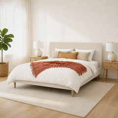 Room 2 angle | Corner view of the ivory bed in a bright room with pale wood nightstands and a rug