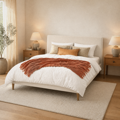 Room 1 angle | Three-quarter room view showing the ivory upholstered bed and brass-tone tapered legs