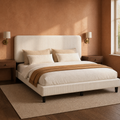 Angled bed view | Upholstered bed styled with bedding in a warm neutral bedroom