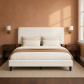 Bedroom scene | Beige upholstered bed styled in a moody clay-colored bedroom