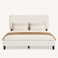 Bedroom scene | Beige upholstered bed framed by a clay-toned wall and warm bedside lighting