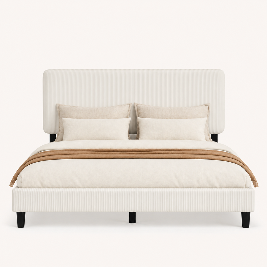 Bedroom scene | Beige upholstered bed framed by a clay-toned wall and warm bedside lighting