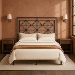 Room 3 | Front view of the gunmetal headboard against a clay wall with brass sconces