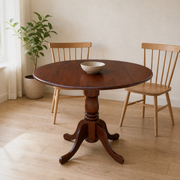 In a room | espresso round drop-leaf table centered in a warm white dining room, window at left, two oak side chairs for scale