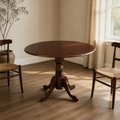 Second room | same espresso drop-leaf table in a warm plaster dining room, window at right, late-afternoon light
