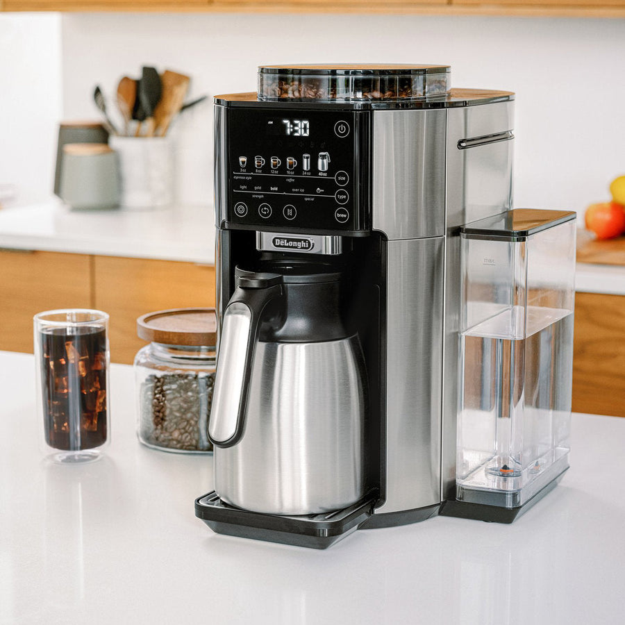 Angle | De'Longhi TrueBrew with thermal carafe on a kitchen counter, water tank and iced coffee glass alongside