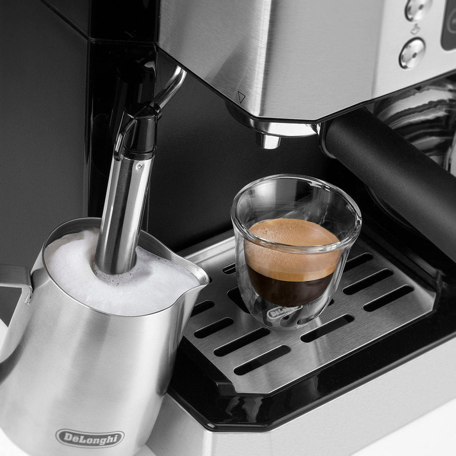 Detail | steam wand frothing milk beside a fresh espresso shot