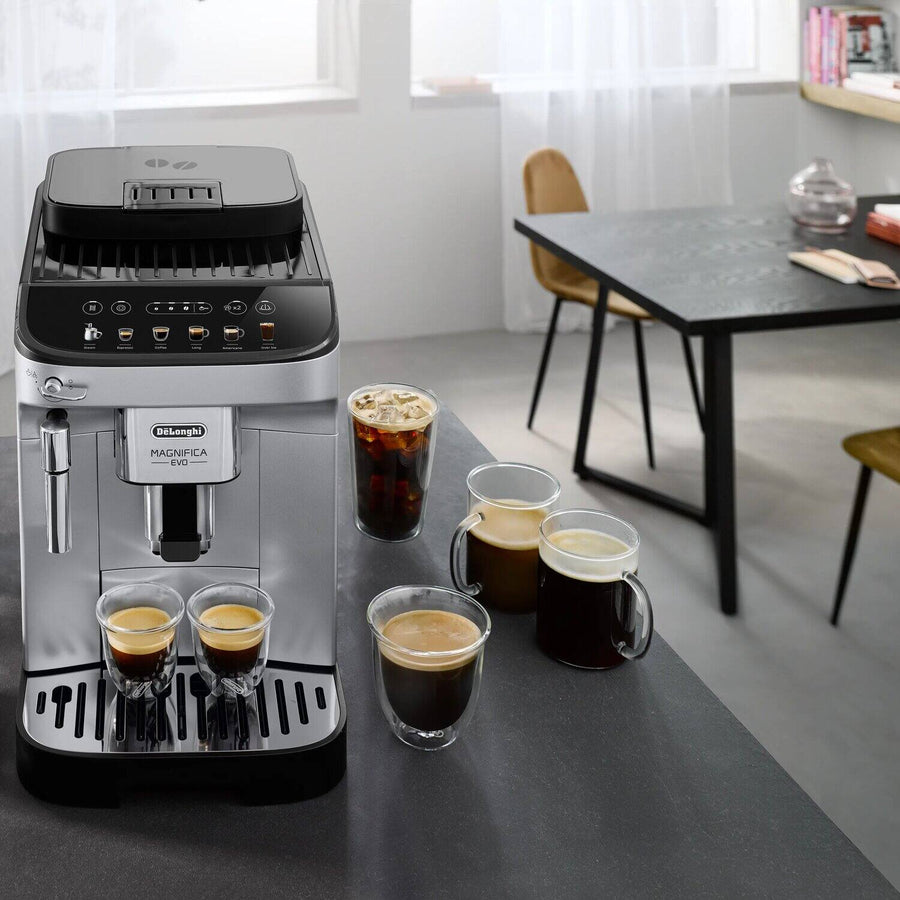Lifestyle | Magnifica Evo espresso machine on a dining room counter with iced coffee and espresso cups nearby