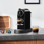 Lifestyle | Nespresso CitiZ espresso machine in black on a kitchen counter with two cups of espresso and capsules