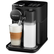 Angle | black machine dispensing a latte into a glass with the milk-frothing jug attached