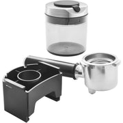 Accessories | the grinder's grounds container with lid, portafilter cradle and a stainless portafilter laid out on white