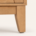 Leg detail | close-up on one tapered wood leg and its foot, the sideboard's only hardware-like detail since the doors are handle-free