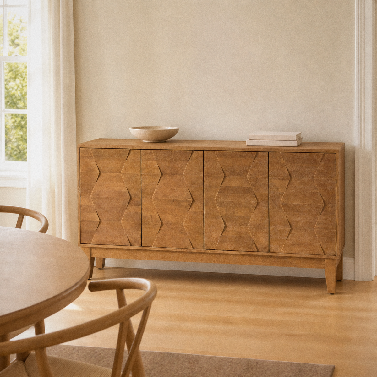 In a room | seadrift 4-door sideboard against a warm flax wall, round table at left, bright midday window light on the faceted doors