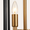Detail | close view of one brass candle sleeve and its fully exposed bulb