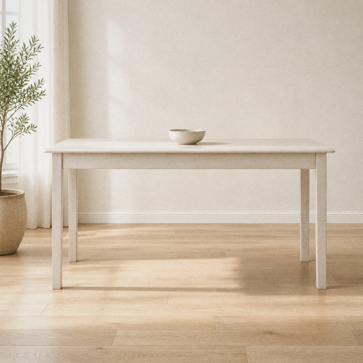 In a room | antique-white rectangular four-leg dining table centered in a warm white dining room, window at left, potted plant, a single bowl on the tabletop