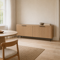 In a flax dining room | reeded sideboard against pale flax walls and maple floor, window and curtain at left