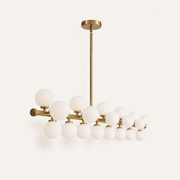 Side | side profile of the Marnau Glazenn 16-light sputnik chandelier on a plain background, showing the depth of the brass arms and frosted glass globes along the bar